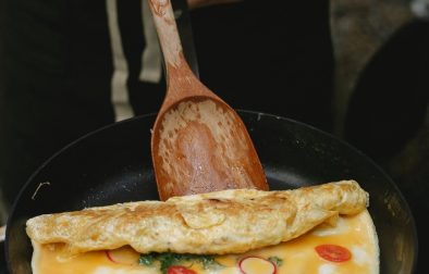 crop faceless chef cooking delicious omelette on pan